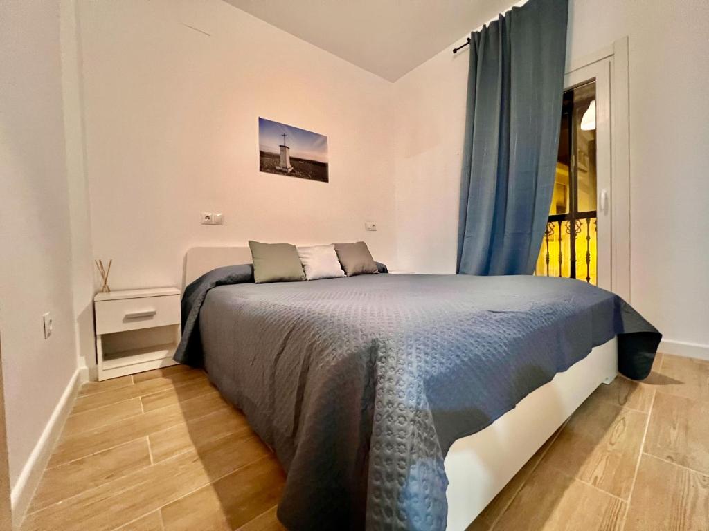 1 dormitorio con cama y ventana en Apartamentos La Albariza Jerez Centro, en Jerez de la Frontera