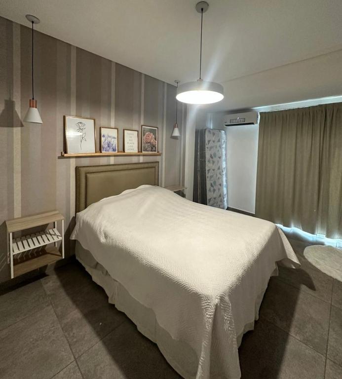 1 dormitorio con 1 cama blanca en una habitación en Depto temporario en Corrientes