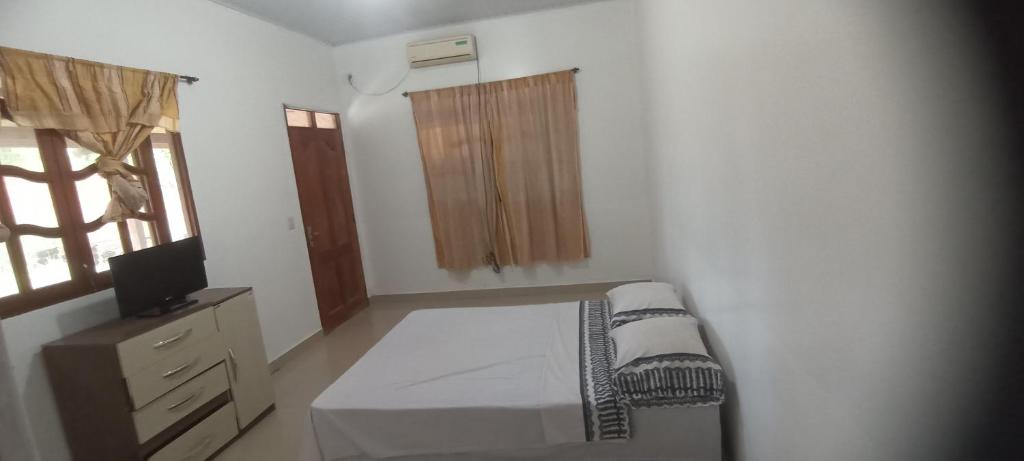 een slaapkamer met een bed, een dressoir en een raam bij Hotel Cedrillos in Cobija
