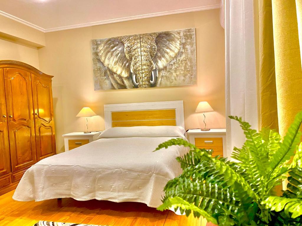 um quarto com uma cama e uma pintura de um elefante em Casa dos sonhos em Chaves