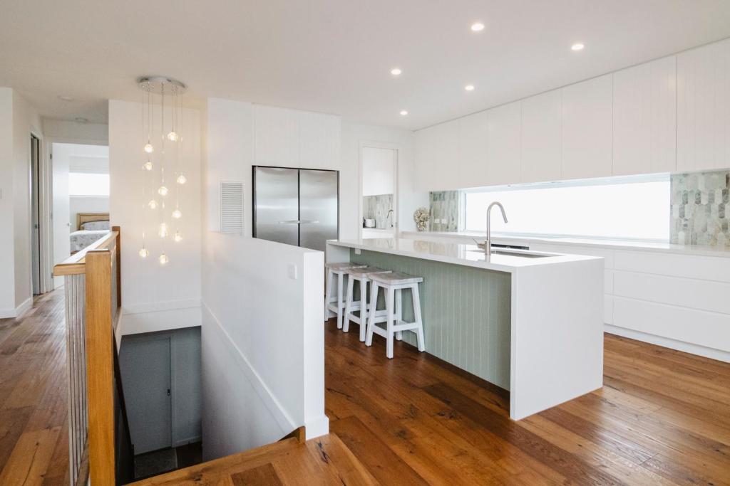 a kitchen with white walls and a kitchen island at Beachside Mornington house in Mornington