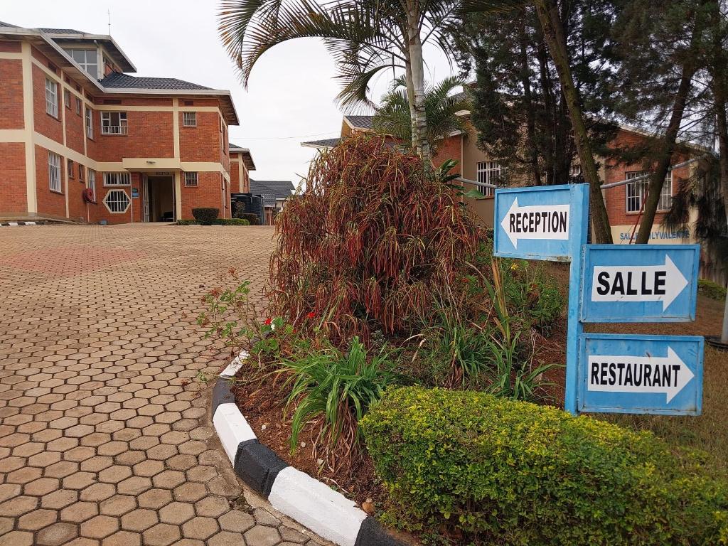 deux panneaux de rue bleus et blancs devant une maison dans l'établissement Centre d'Accueil Bonne Esperance Rwanda, à Kigali