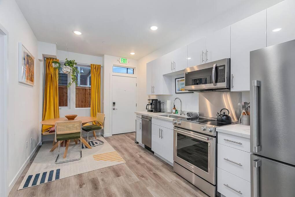 a kitchen with a stainless steel refrigerator and a table at Calm Urban Abode steps to Volunteer Park in Seattle