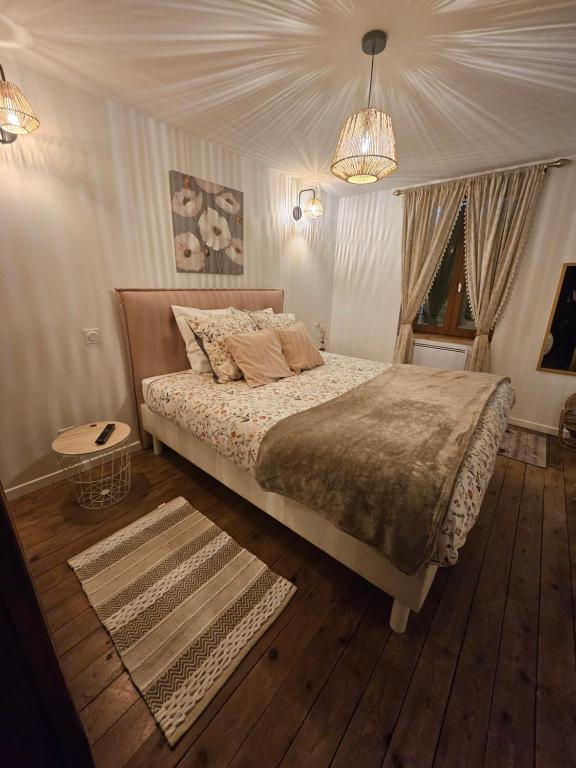 une chambre avec un lit et un lustre dans l'établissement Gite le Montinho, à Fontevraud-l'Abbaye