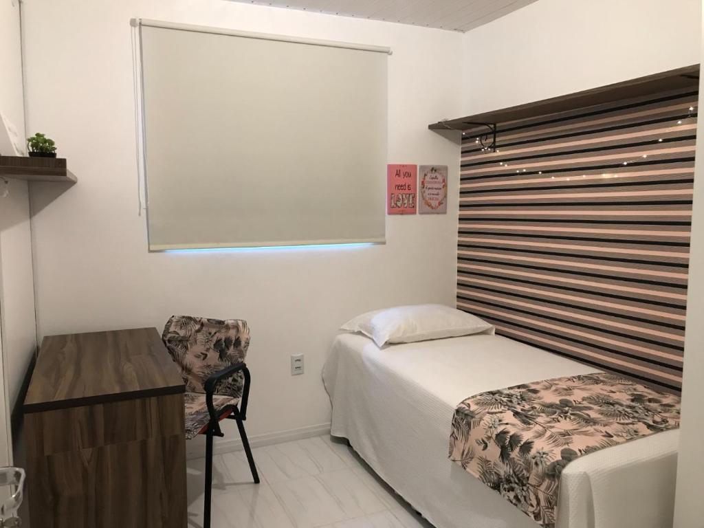 - une chambre avec un lit, un bureau et une fenêtre dans l'établissement República Descolada! Quarto exclusivo p/ mulheres!, à Florianópolis