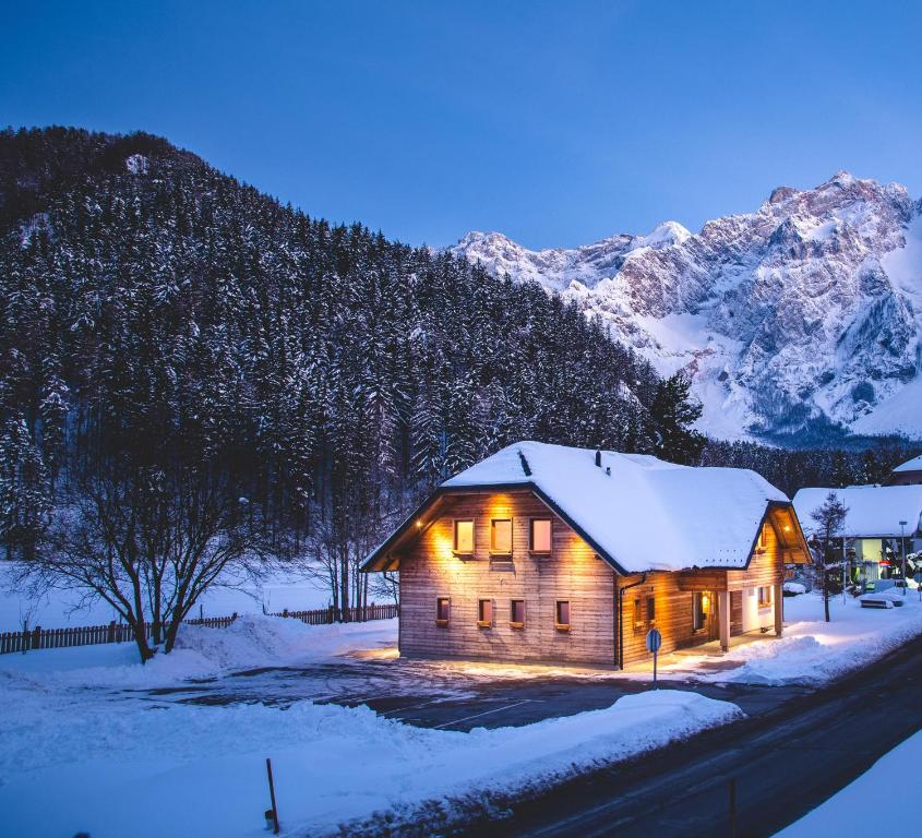 une cabine dans la neige avec une montagne en arrière-plan dans l'établissement Rooms Kočna, à Zgornje Jezersko