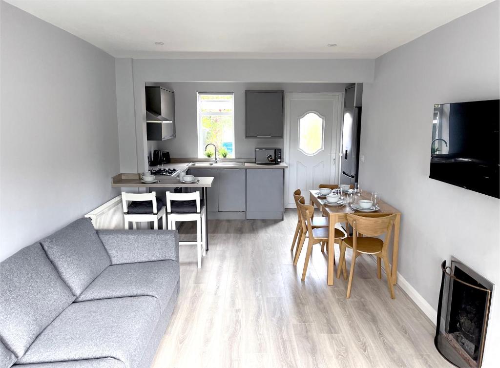 een woonkamer en een keuken met een bank en een tafel bij Smithdown Rooms in Liverpool