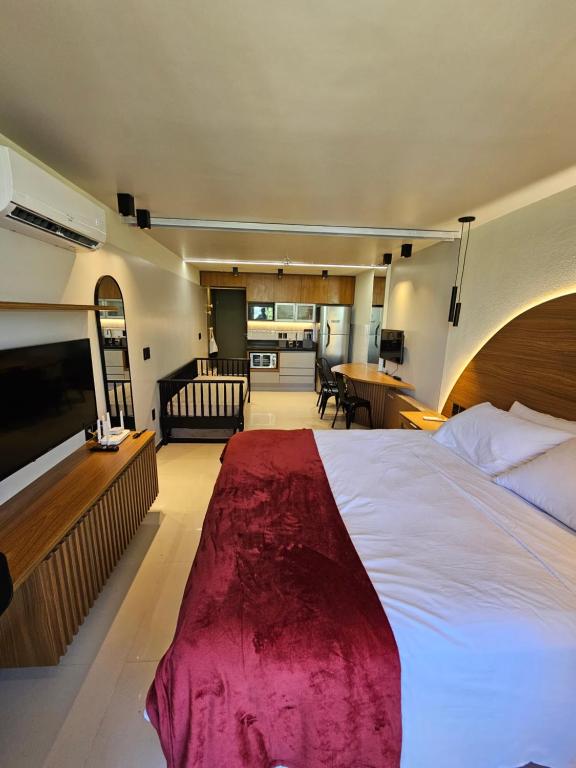 Praia dos Carneiros flat hotel في تامانداري: غرفة نوم بسرير كبير وغرفة معيشة