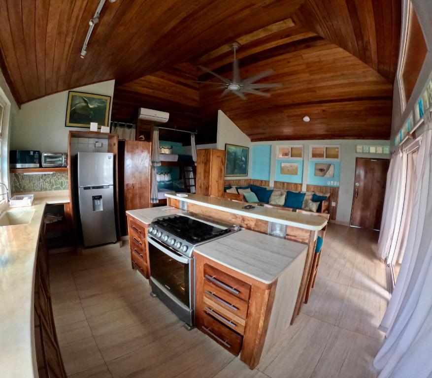 a kitchen with wooden ceilings and a stove top oven at Turtles Nest Bunkhouse at Lodge at Long Bay in Corn Islands