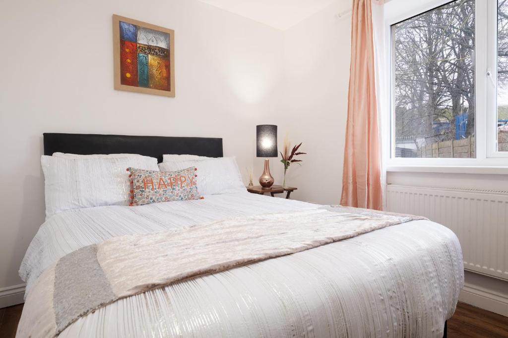 a bedroom with a large white bed with a window at Flat in west midlands in Longford