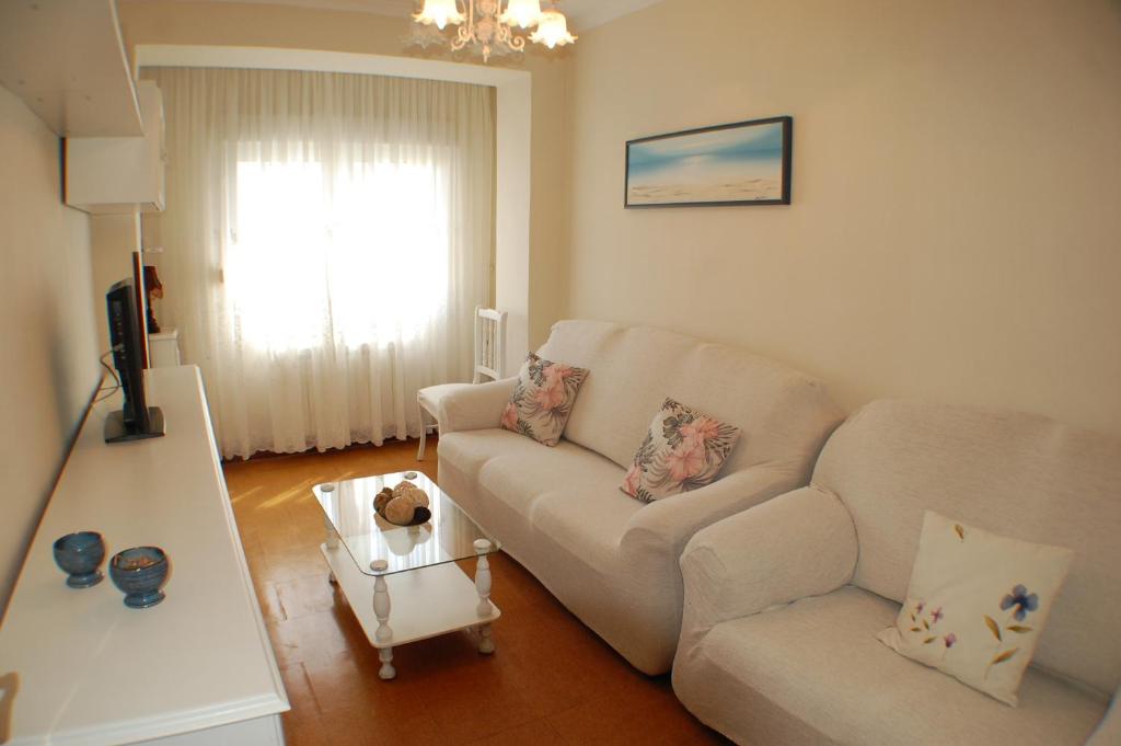 Apartamento La Luz de Reinosa 1 في رينوسا: غرفة معيشة مع أريكة وطاولة