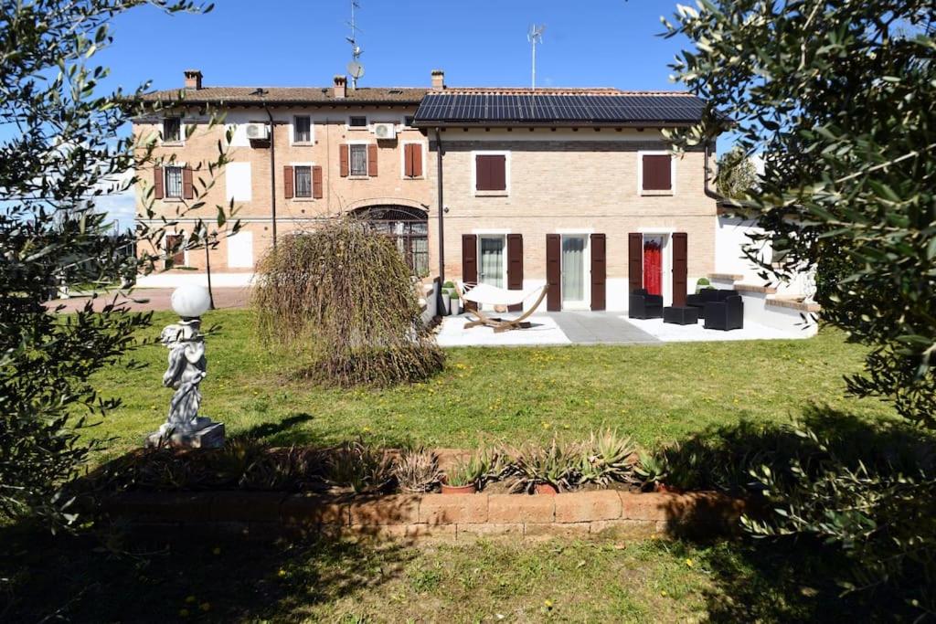 una casa grande con una estatua delante de ella en La casa del gufo - B&B la Casa di Graz, en Reggio Emilia