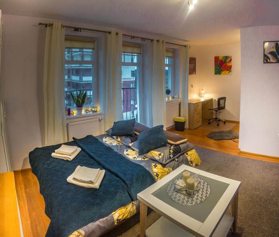 um quarto com uma cama azul e uma mesa em Komfortowy Apartament Belweder em Olsztyn