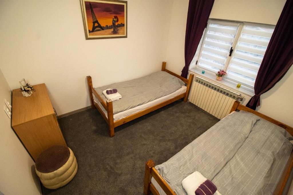 a small room with two beds and a window at Guest House Lejla in Travnik