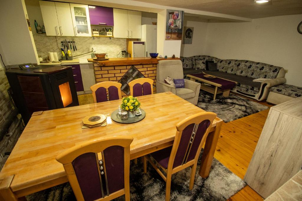 a kitchen and living room with a wooden table and chairs at Guest House Lejla in Travnik