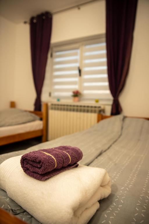 a purple towel sitting on top of a bed at Guest House Lejla in Travnik