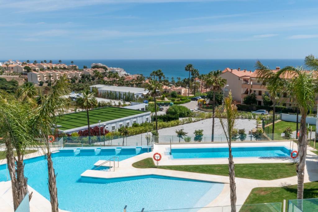 widok na basen w ośrodku z palmami w obiekcie Luxury 2BR Seaviews - Santa Barbara Heights w mieście Fuengirola