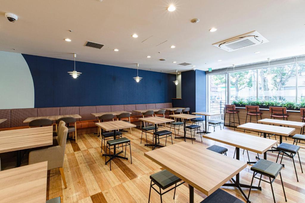 comedor con mesas y sillas de madera en Hotel Lumiere Nishikasai en Tokio