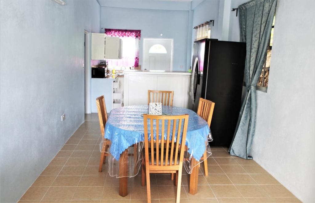 a kitchen with a table with chairs and a refrigerator at Paradise Apartment in Castries