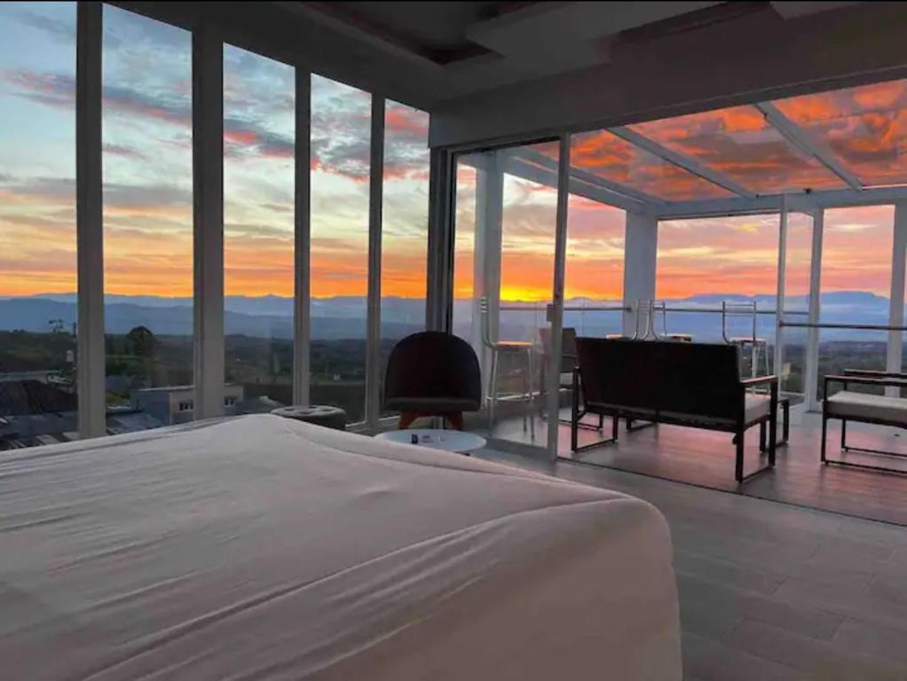 1 dormitorio con cama y vistas a la puesta de sol en Penthouse - Vista Hermosa Apartments, en Filandia