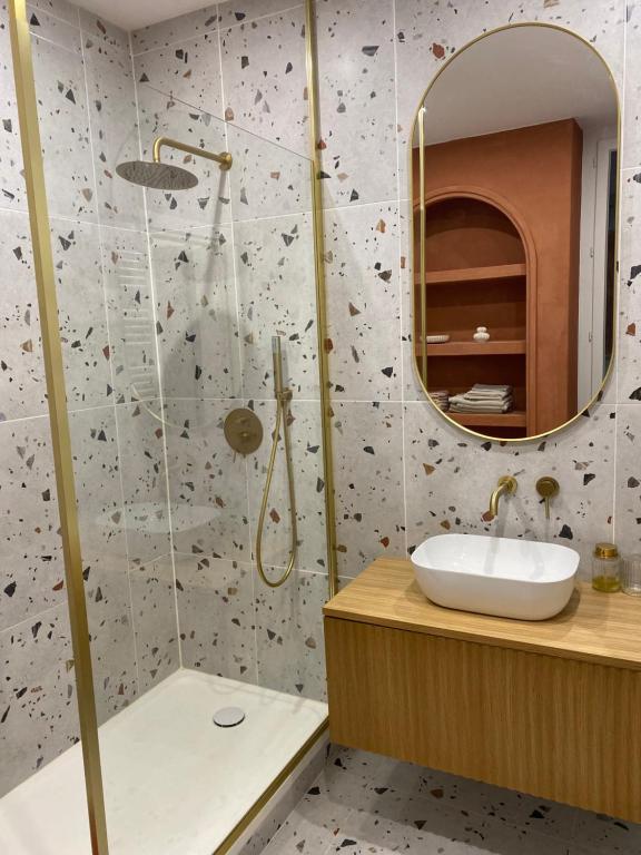 ein Bad mit einer Dusche, einem Waschbecken und einem Spiegel in der Unterkunft Nîmes Appartement de charme Terracotta in Nîmes
