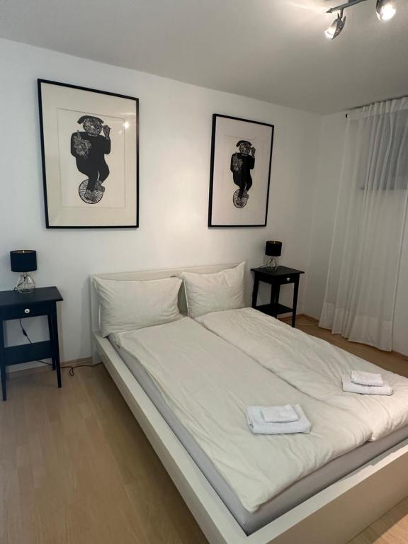 - un lit blanc dans une chambre avec deux tables dans l'établissement Gemütliche Ferienwohnung in Wolfhagen mit Terrasse, à Wolfhagen