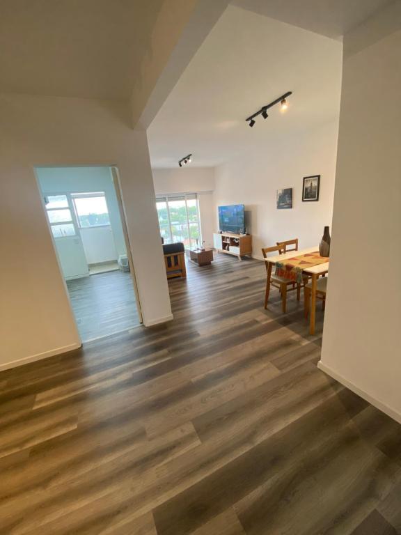 een woonkamer met een houten vloer en een tafel bij Vicente Lopez 2 ambientes 4 personas in Florida