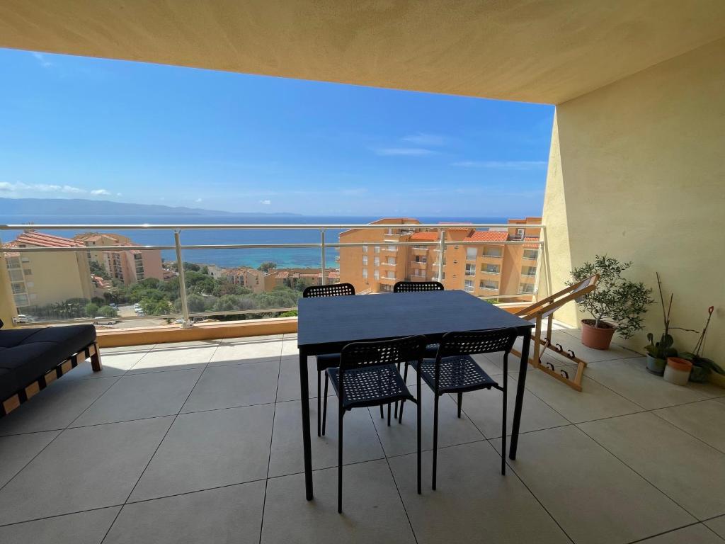 une table et des chaises sur un balcon avec vue dans l'établissement Appartement T3 face à la mer, à Ajaccio