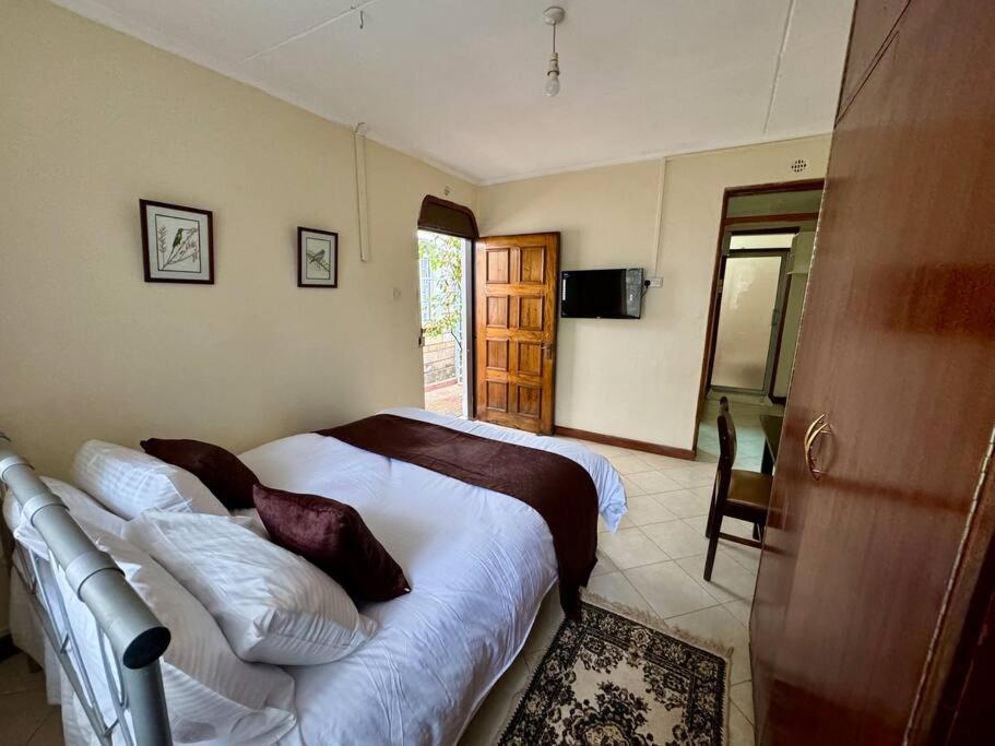 a bedroom with a bed and a television in it at Charming Retreat in Garden Estate-Thome, Thika Rd in Nairobi