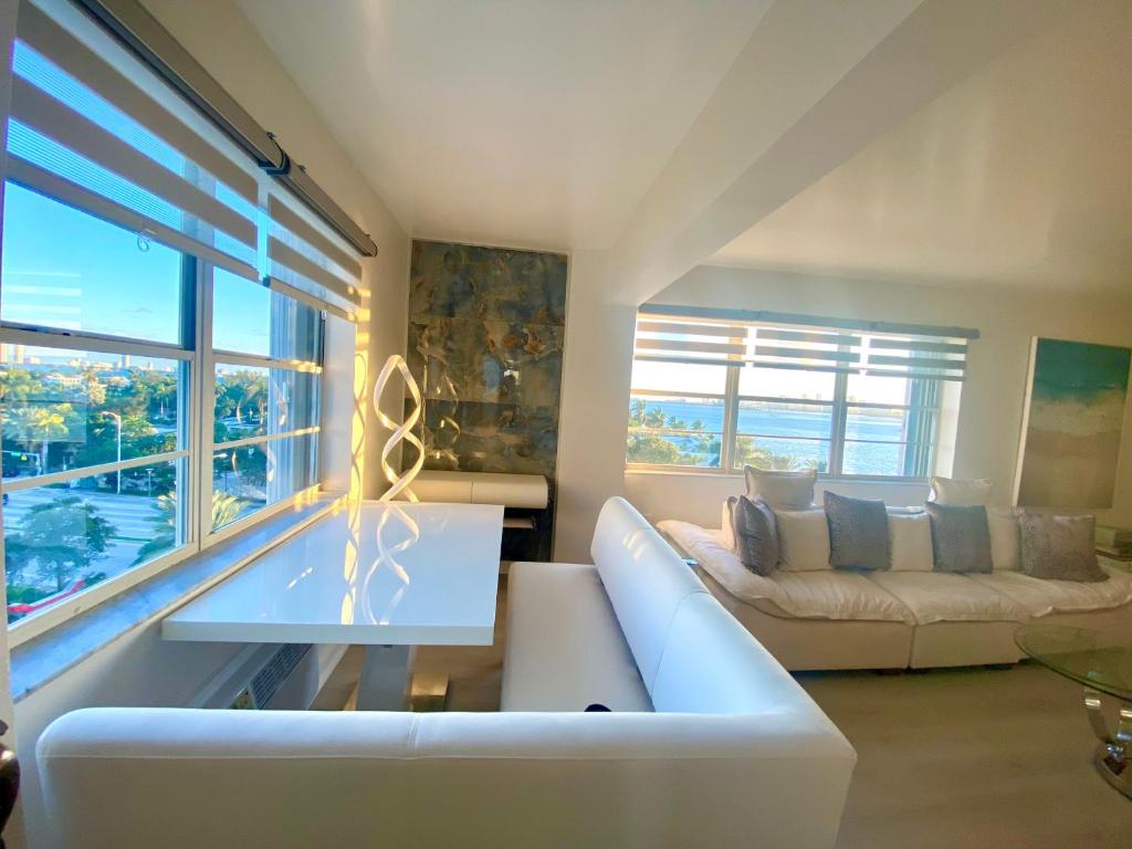 a living room with a white couch and a large window at Panoramic luxurious waterfront one bedroom apartment with Miami skyline view Free parking 5min drive to Miami Beach in Miami Beach