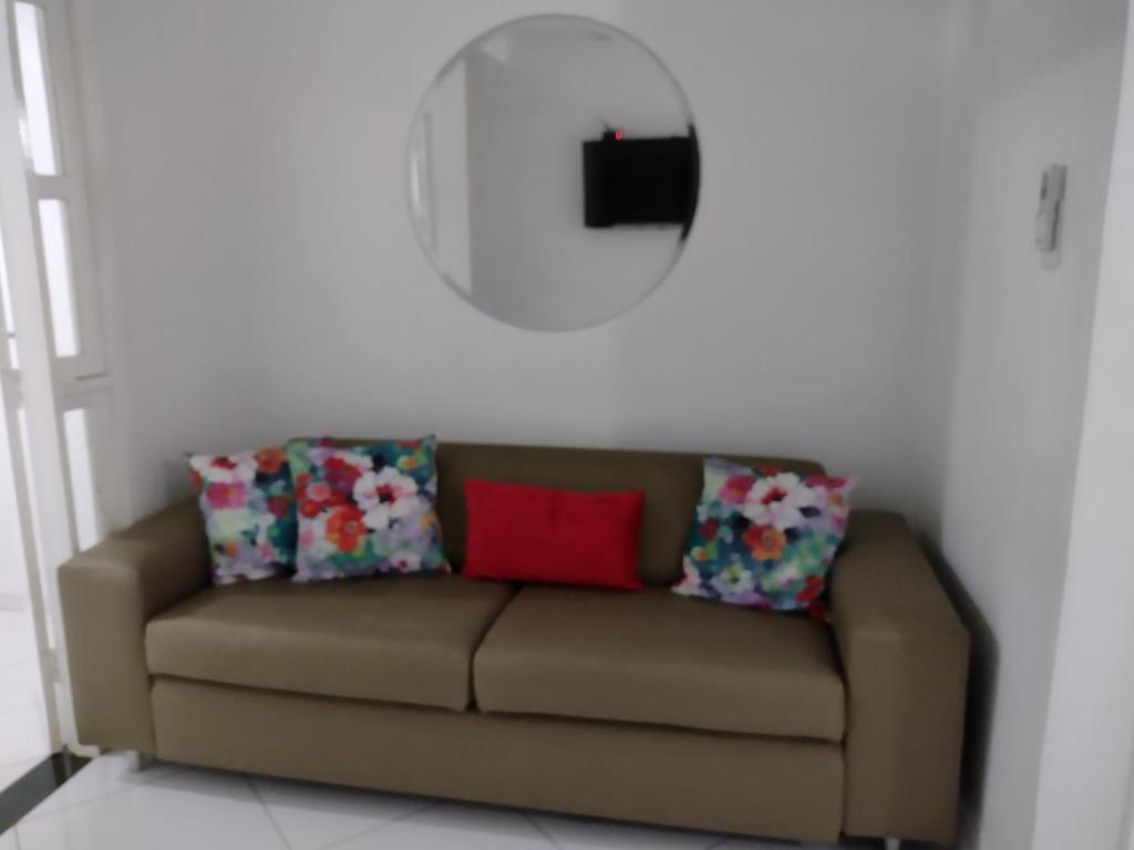 a brown couch with two pillows and a mirror at Fantástico in Santo Amaro