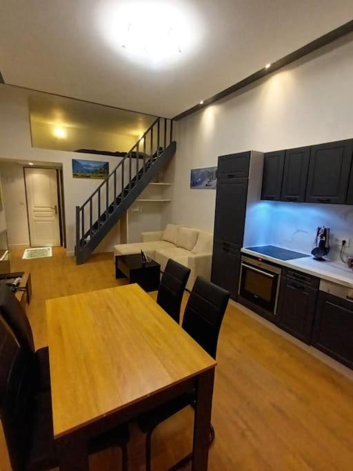 ein Wohnzimmer mit einem Tisch und einer Küche in der Unterkunft Grand studio avec mezzanine in Voiron