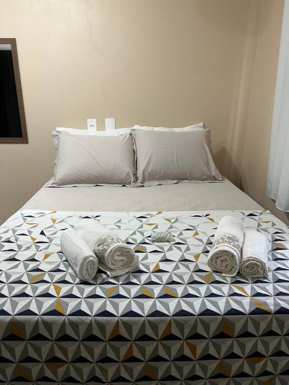 Una cama con toallas y almohadas. en Suite 3- Nud Praia bonita Hospedagem en São Francisco do Sul