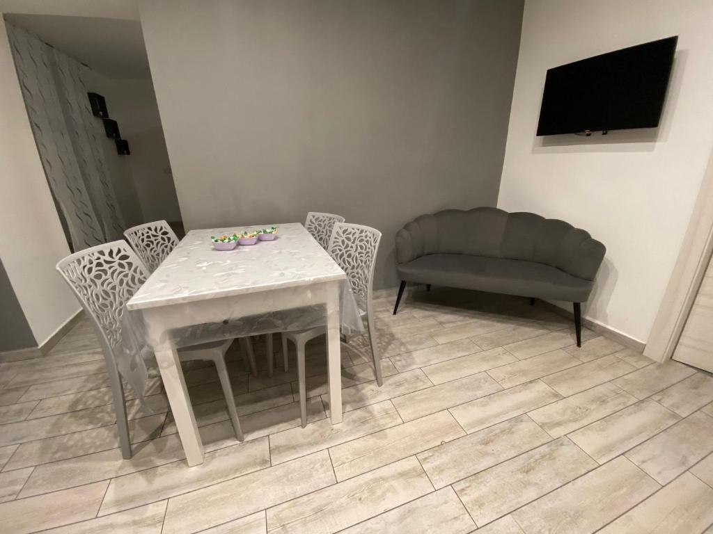 a living room with a table and chairs and a couch at Casa vacanze Figurelle in Naples