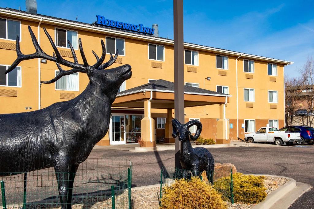 uma estátua de um veado e um veado bebé em frente a um hotel em Rodeway Inn Central Colorado Springs em Colorado Springs