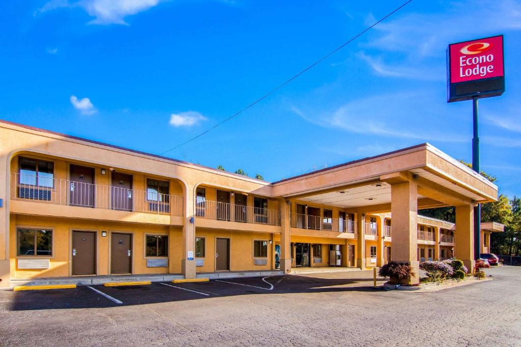 una vista frontal de un hotel con una señal de alquiler en Econo Lodge Atlanta Airport East en Forest Park