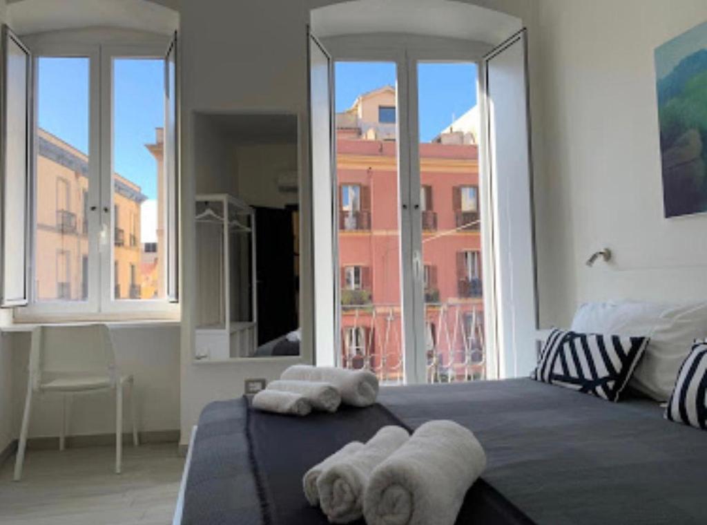 una camera da letto con due asciugamani su un letto con finestre di Angel Room Nel Corso a Cagliari