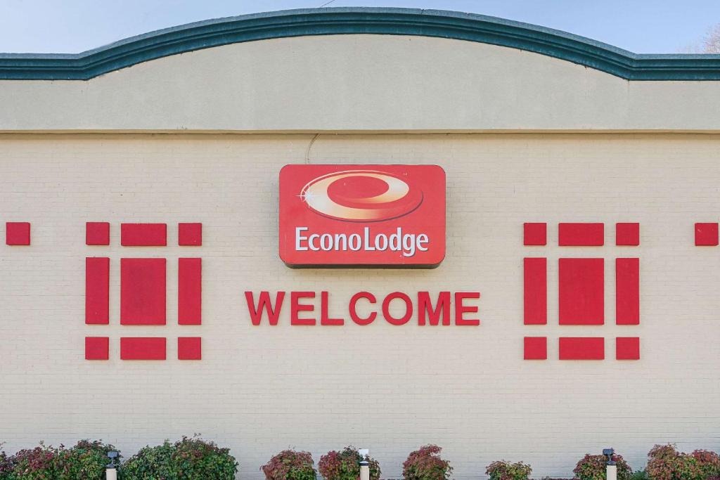 una señal en el lateral de un edificio con una señal de bienvenida en Econo Lodge, en Martinsville