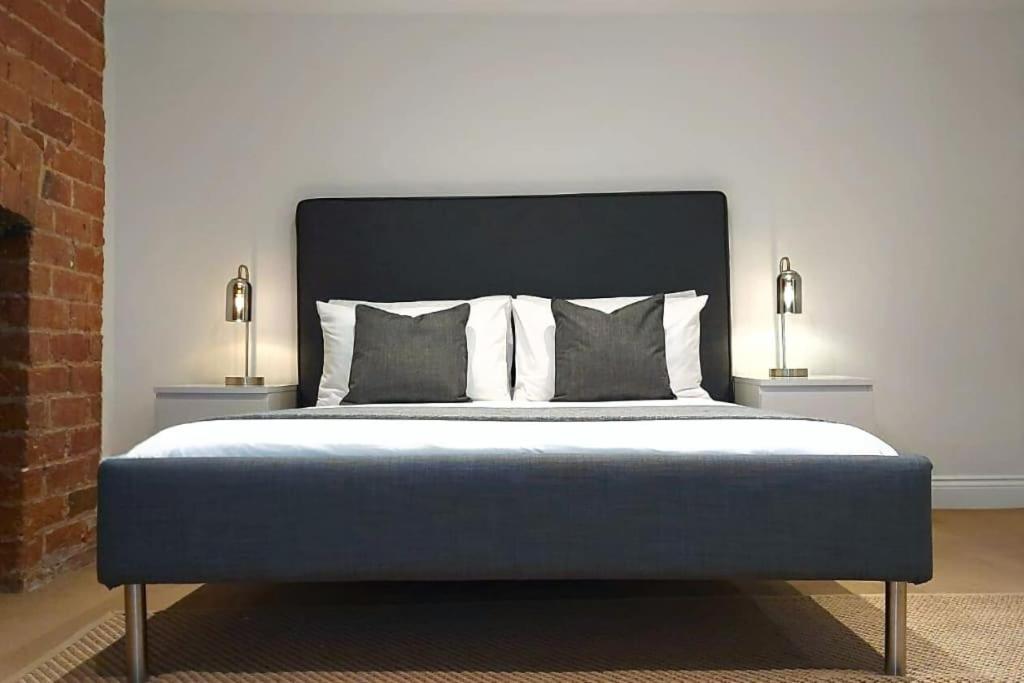 2 Bedroom City Centre Duplex Apt في بريستون: غرفة نوم مع سرير ومصباحين من الجهتين