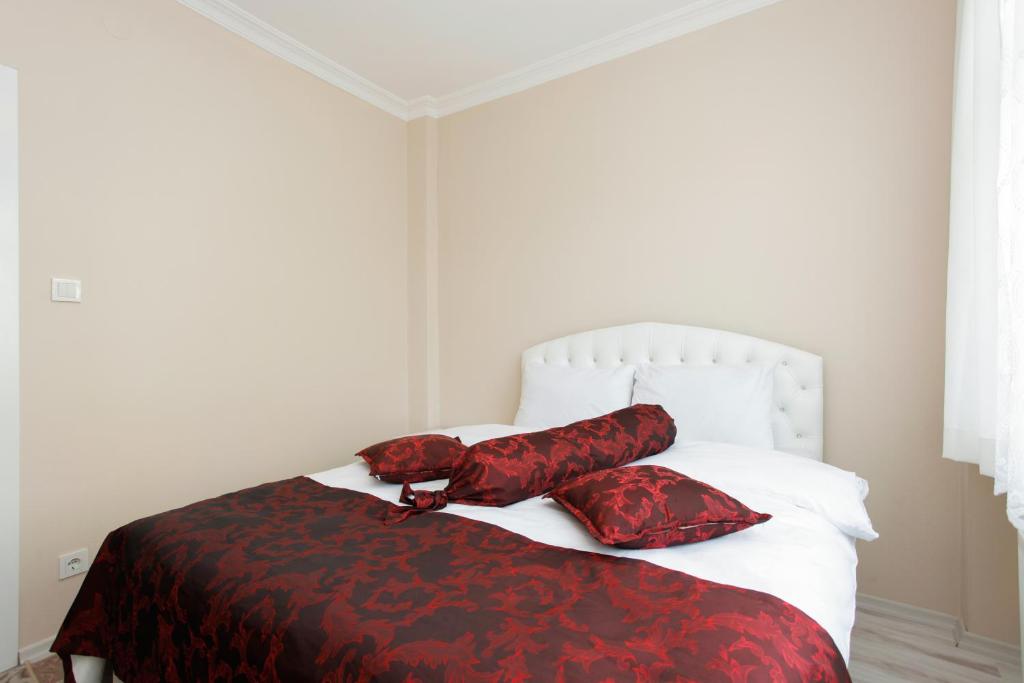 a bedroom with a bed with red and black sheets and pillows at Blue Sultan Apart in Istanbul