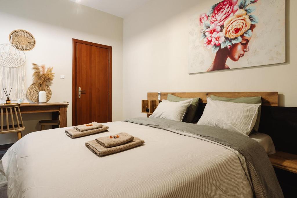 sypialnia z łóżkiem z ręcznikami w obiekcie Floret Apartment w Salonikach