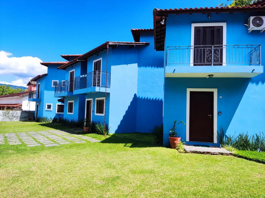 una casa azul con un patio verde en Casa Azul Perequê, en Ilhabela