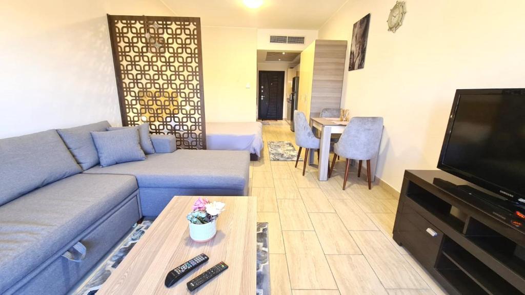 un salon avec un canapé bleu et une télévision dans l'établissement ALDau heights koko, à Hurghada