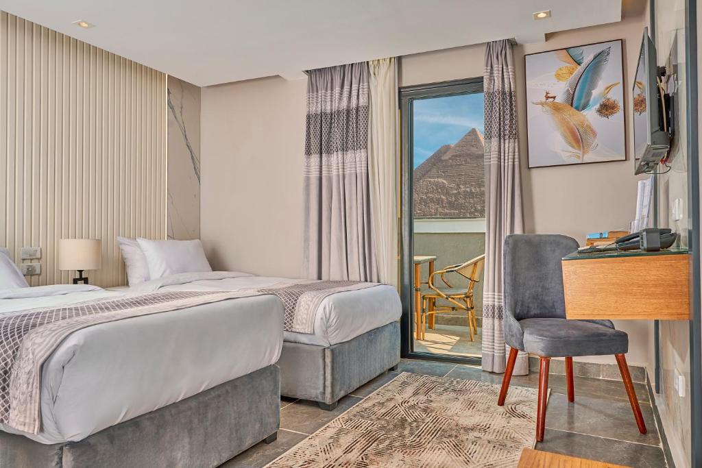 um quarto de hotel com uma cama, uma secretária e uma janela em Khan Duidar Inn - Pyramids View Rooftop em Cairo
