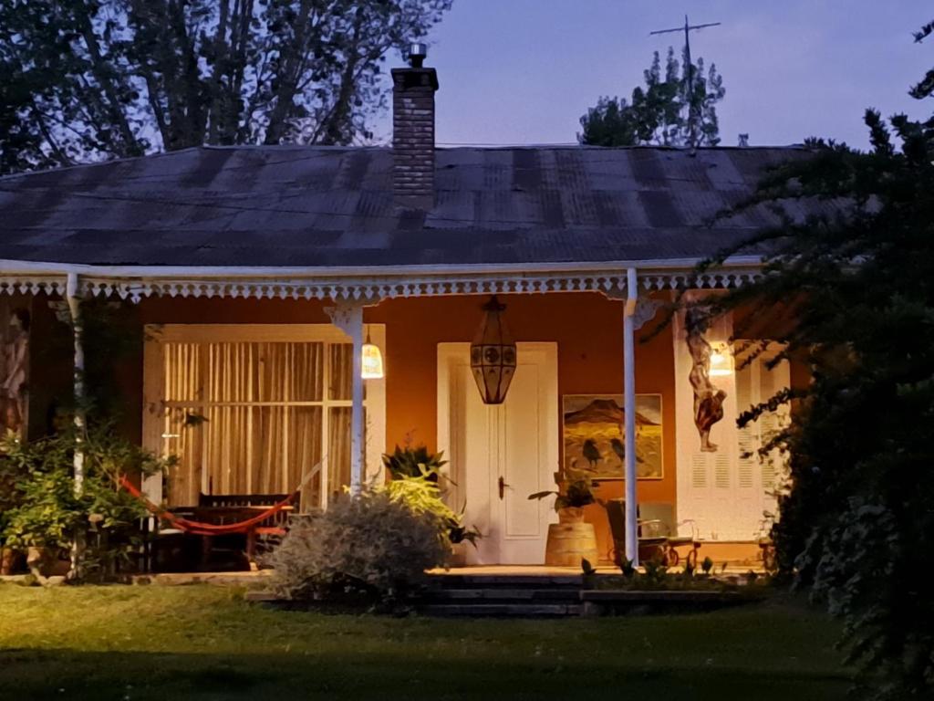 ゴドイ・クルスにあるcasona trapicheの夜のポーチ付き小さな白い家