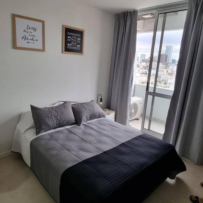 a bedroom with a bed and a window with a view at El arte suites COCHERA PRIVADA in Buenos Aires