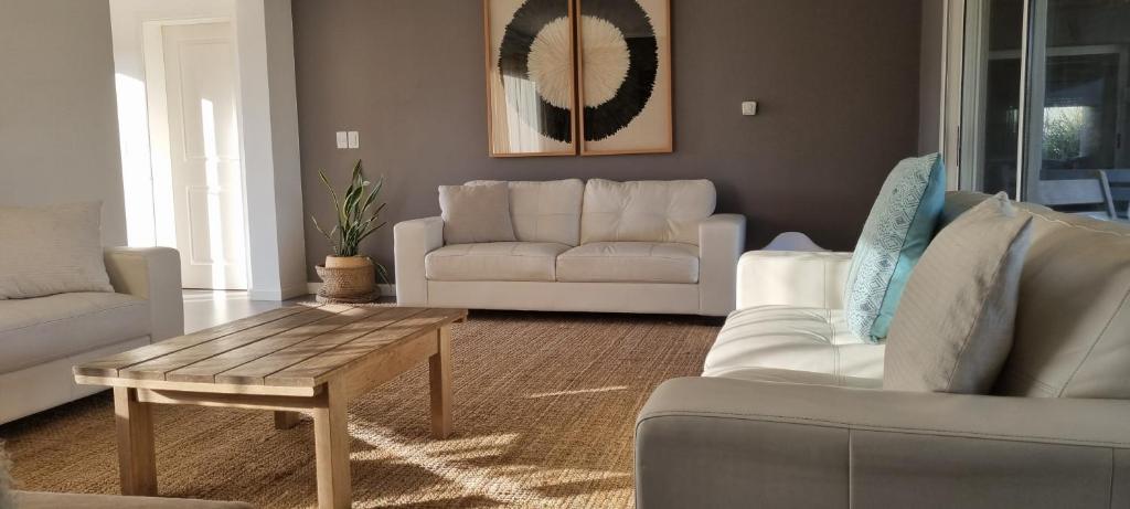 uma sala de estar com sofás brancos e uma mesa de centro em zona de lagos , barrio country em Colonia Nicolich