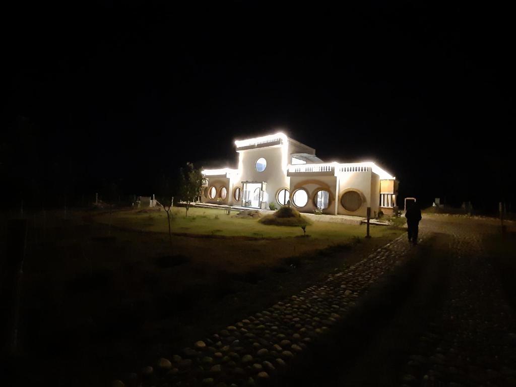 Un uomo che cammina di notte davanti a un palazzo di Vedic Farms a Garhshankar