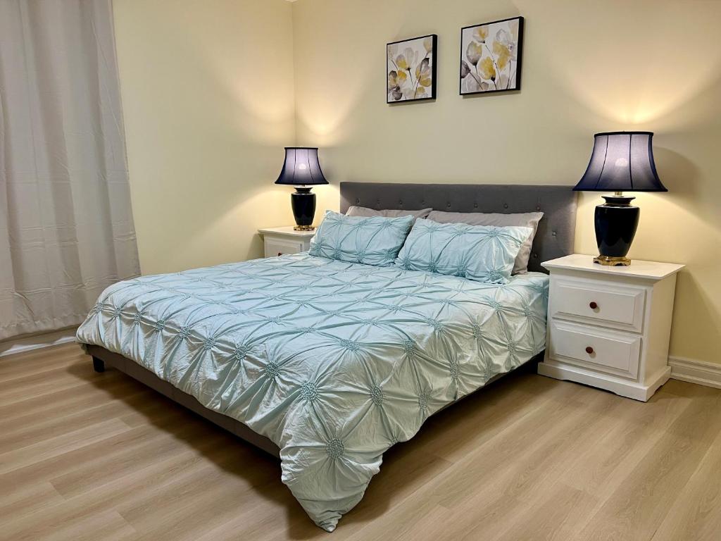 ein Schlafzimmer mit einem Bett mit zwei Nachttischen und zwei Lampen in der Unterkunft Luxury Suite with King Bed-4 minutes to The Falls in Niagara Falls