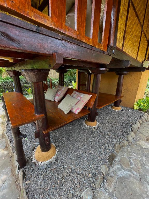 a bench under a wooden table with books on it at Rinjani Lighthouse in Senaru